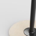 Close-up van de lichte houten voet en zwarte kolom van de Varier Move balanskruk.